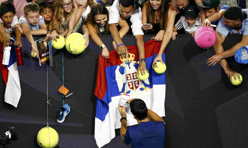 El serbio Novak Djokovic firma autógrafos después de ganar su partido de la segunda ronda ante el francés Quentin Halys en el torneo de tenis Abierto de Australia en Melbourne Park, Australia, 20 de enero de 2016. REUTERS / Thomas Peter