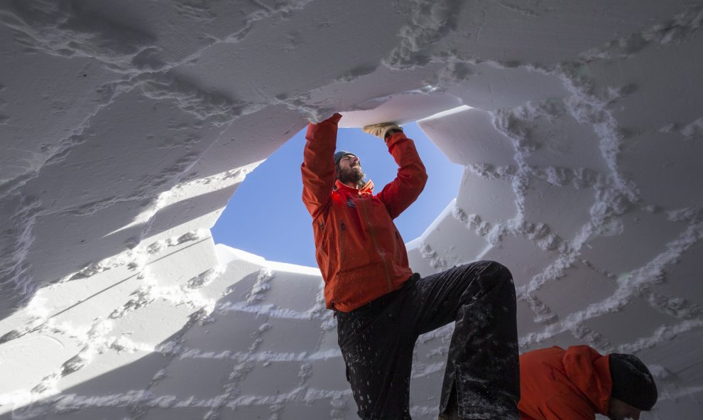 El director del Igloo-village (pueblo de iglús), Reto Gilli, apila los últimos ladrillos de nieve durante la construcción del iglú más grande del mundo con un diámetro de 13 metros y 11 metros de alto en Zermatt (Suiza) hoy, 21 de enero de 2016. En su co