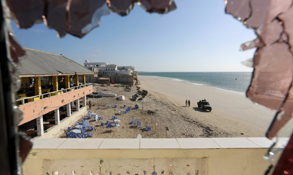 Vista general a través de un cristal roto muestra a las fuerzas del gobierno que patrullaban en la playa de Lido, tras un ataque en el restaurante junto a la playa Beach View Cafe en la capital de Somalia, Mogadiscio. REUTERS/Feisal Omar