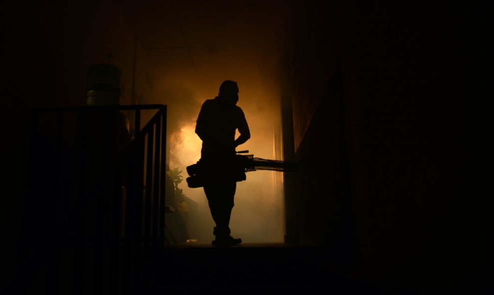 Un empleado del Ministerio de Sanindad fumiga una casapara evitar la propagación del virus Zika, en Soyapango, a 6 km al este de San Salvador. AFP PHOTO / Marvin RECINOS