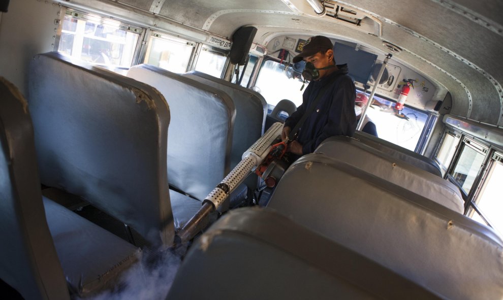 Un empleado de Salud Pública fumiga el interior de un autobús para erradicar el mosquito Aedes aegypti, transmisor del virus del Dengue Chikungunya y Zika, en Tegucigalpa (Honduras).EFE/ Gustavo Amador