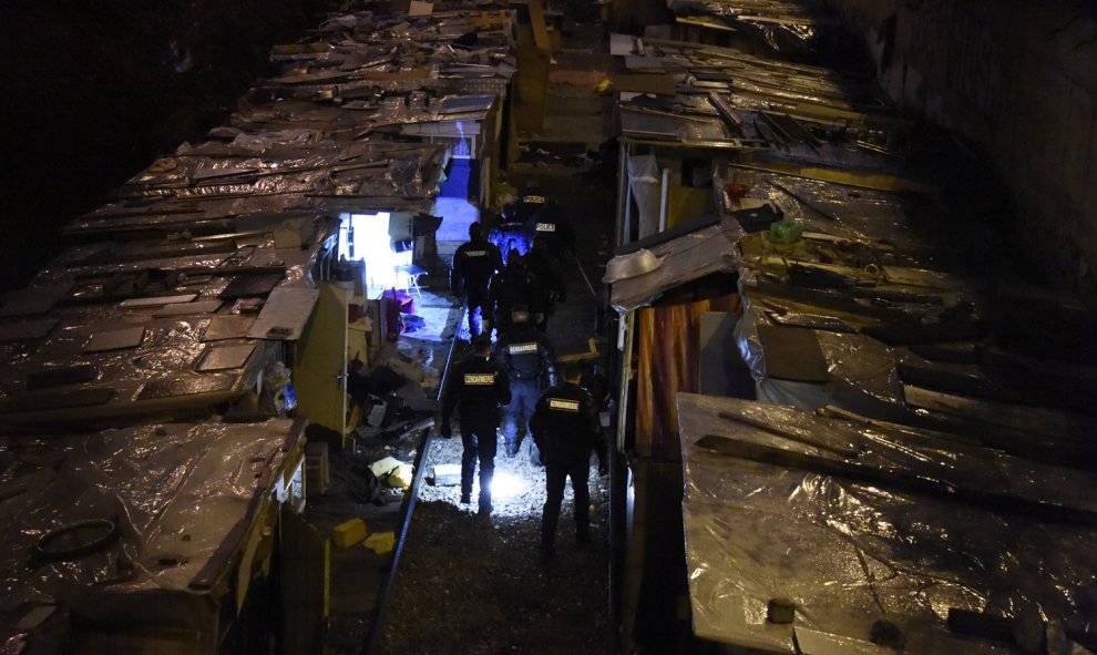 Policías evacúan un campamento de gitanos emigrantes, en las antiguas vías del tren a lo largo del bulevar Ney en el norte de París, 3 de febrero de 2016. Cientos de personas fueron evacuadas. AFP / DOMINIQUE FAGET