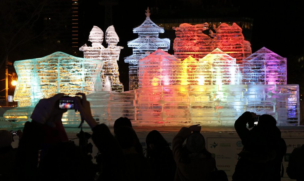 Un grupo de personas fotografía una escultura de hielo gigante iluminada en el festival invernal de Sapporo en el parque Odori, Sapporo (norte de Japón) hoy, 4 de febrero de 2016. Temperaturas bajo cero y espectáculo se conjugan durante una semana en la c