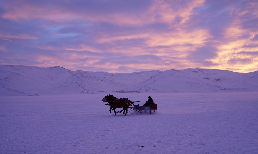 Un hombre monta un carro tirado por caballos en el lago congelado Cildir en la provincia de Kars, en Turquía. REUTERS/Umit Bektas