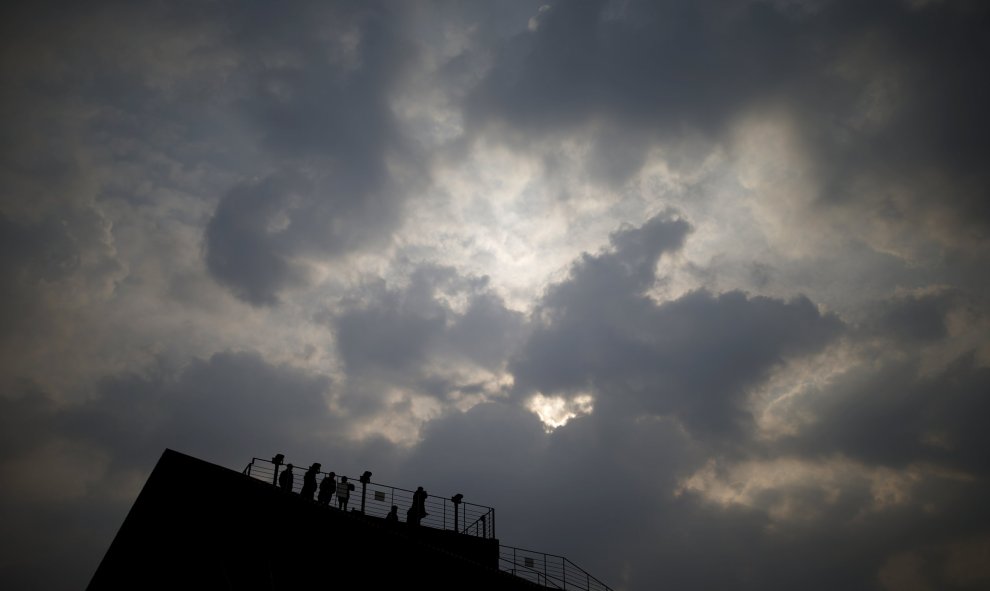 Personas miran hacia el norte con prismáticos desde un observatorio cerca de la zona desmilitarizada que separa las dos Coreas. REUTERS/Kim Hong-Ji