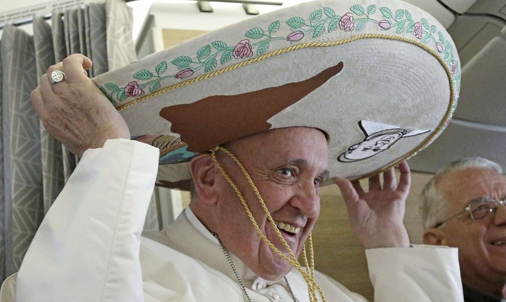 El Papa Francisco lleva un sombrero que recibió como regalo de un periodista mexicano, a bordo de un avión a La Habana. REUTERS/Alessandro Di Meo