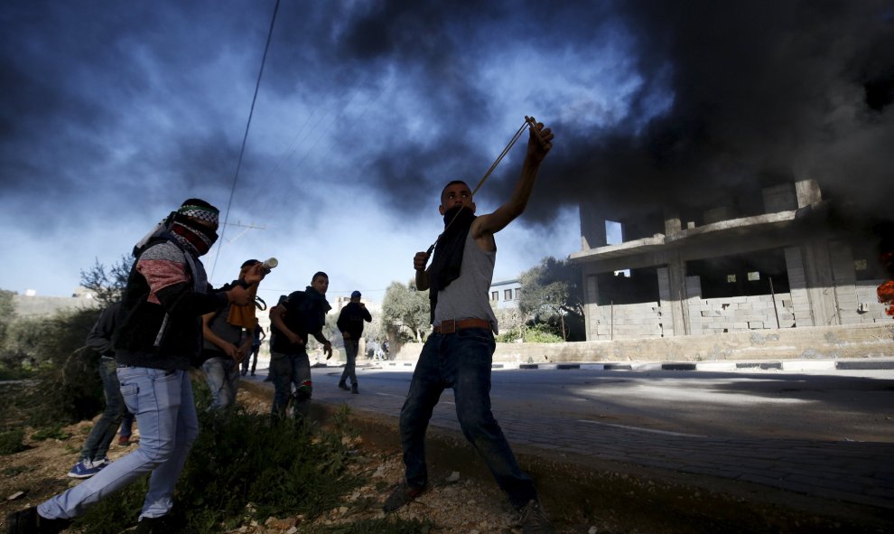 Un manifestante palestino lanza piedras hacia las tropas israelíes durante los enfrentamientos en la localidad cisjordana de araka cerca de Jenin, 15 de febrero de 2016. REUTERS / Mohamad Torokman