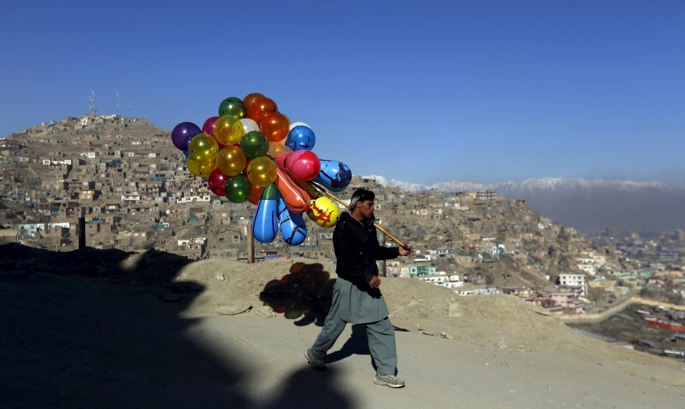 Un hombre afgano sostiene globos puestos a la venta en Kabul, Afganistán. REUTERS/Mohammad Ismail