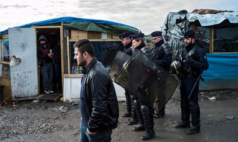 Varios agentes de la Compañía Republicana de Seguridad (CRS) patrullan el campamento temporal 'La Jungla', en las afueras de Calais, Francia. EFE/Yoan Valat
