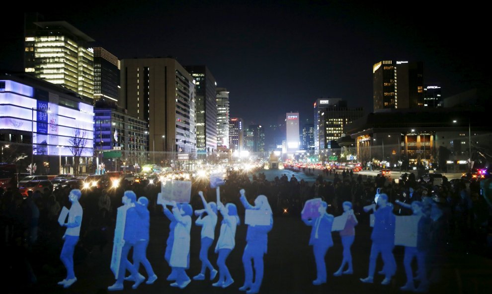 Proyectan la imagen de personas marchando durante una manifestación de estilo holograma organizado por el grupo de derechos humanos Amnistía Internacional para exigir la libertad de reunión en el centro de Seúl, Corea del Sur , 24 de febrero de 2016. REUT