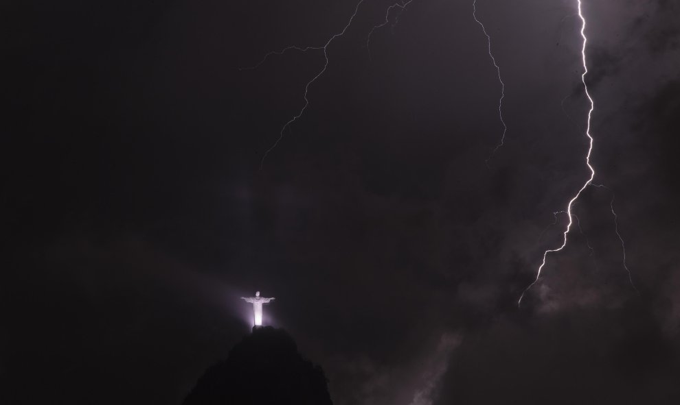 Fotografía de un rayo frente a la imagen del Cristo Redentor durante una tormenta anoche en la ciudad de Río de Janeiro (Brasil). EFE/Marcelo Sayão