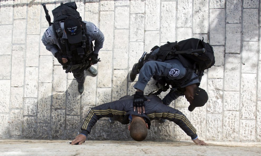 Policías registran a un palestino sospechoso en la inmediaciones de Damasco en Jerusalén. La seguridad se ha incrementado en la ciudad para limitar el número de ataques contra israelíes. EFE/Atef Safadi