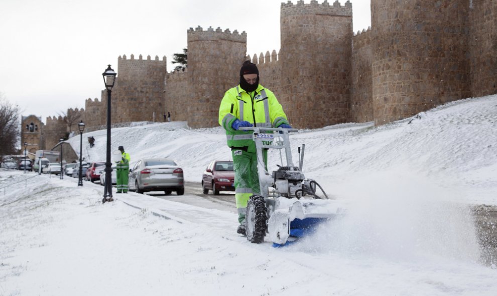 Un operario retira la nieve acumulada junto a la Muralla de Ávila, que hoy amenecía bajo un manto blanco debido al temporal de frío y nieve que afecta a gran parte del país.  EFE/Raúl Sanchidrián