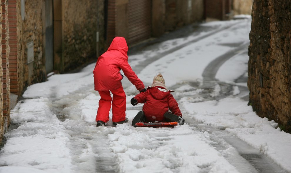 Dos niños en una calle de Vilanova de Prades tras la nevada caída en la zona. EFE/Jaume Sellart