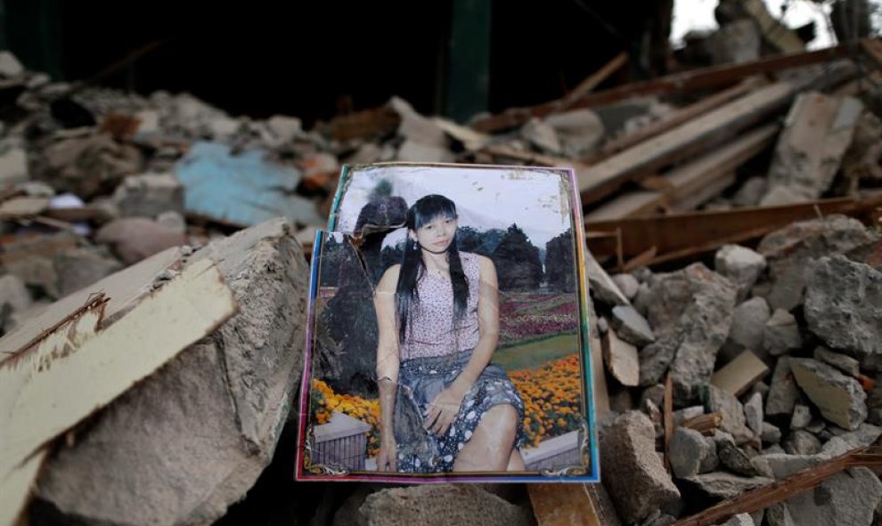 El retrato de una mujer permanece entre las ruinas de un club nocturno durante la demolición del barrio rojo de Kalijodo en Yakarta (Indonesia). EFE/Mast Irham