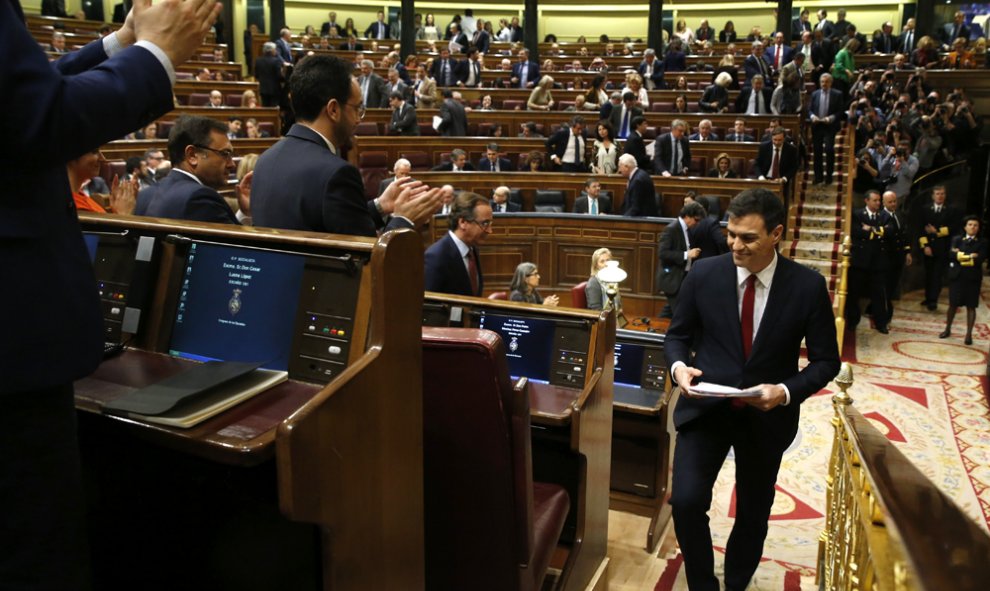 El secretario general del PSOE, Pedro Sánchez (d), es aplaudido por su grupo parlamentario tras su intervención en la primera jornada de la sesión de su investidura, esta tarde en el Congreso de los Diputados. EFE/J. J. Guillén