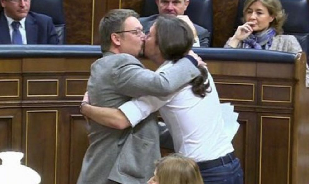Xavier Domenech, portavoz de En Comú Podem, se besa con Pablo Iglesias.