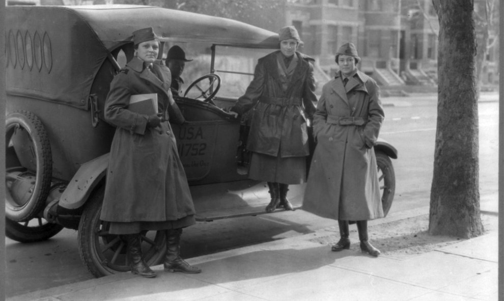 Los miembros del Cuerpo de Radio de la Mujer de pie junto a un coche del ejército.- REUTERS