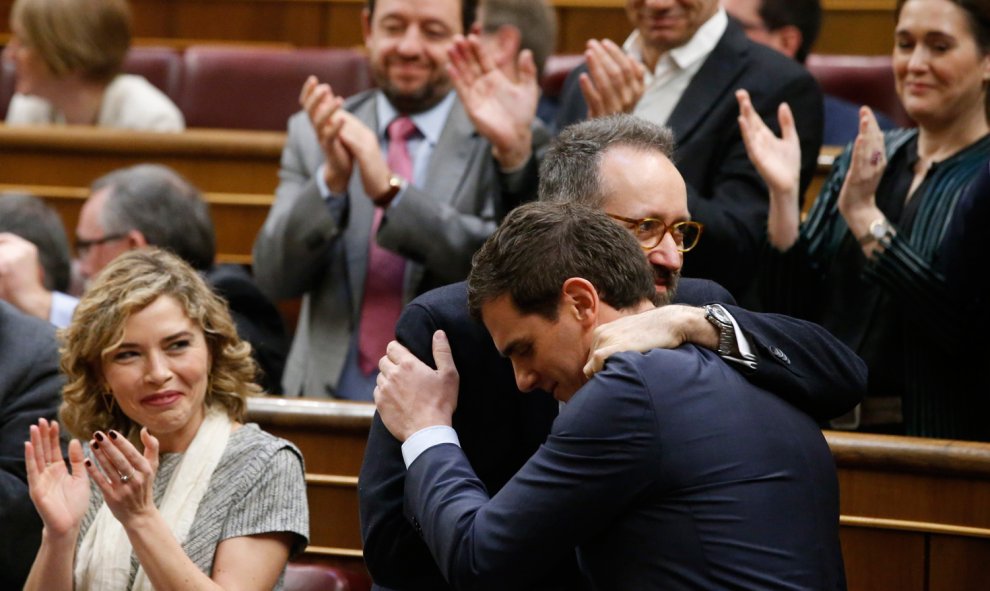 El presidente de Ciudadanos, Albert Rivera (d), es felicitado por el diputado de su formación Juan Carlos Girauta (c), en presencia de la diputada de Ciudadanos Marta Martín (i), durante la segunda jornada del debate de investidura del secretario general