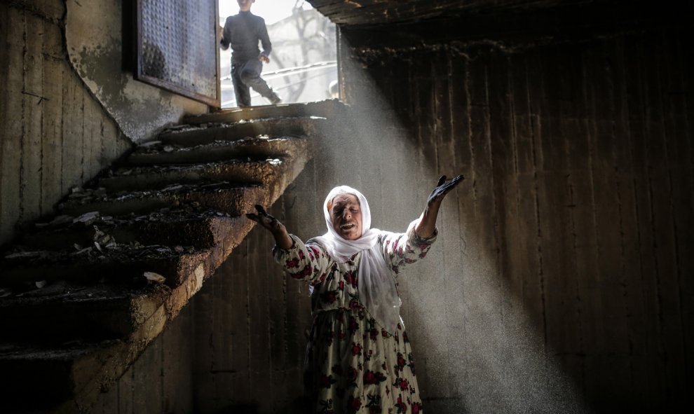 Una mujer reacciona al caminar entre las ruinas de los edificios dañados como consecuencia de los intensos combates entre las tropas gubernamentales y los combatientes kurdos, el 2 de marzo de 2016 en el sudeste de la ciudad kurda de Turquía de Cizre, cer
