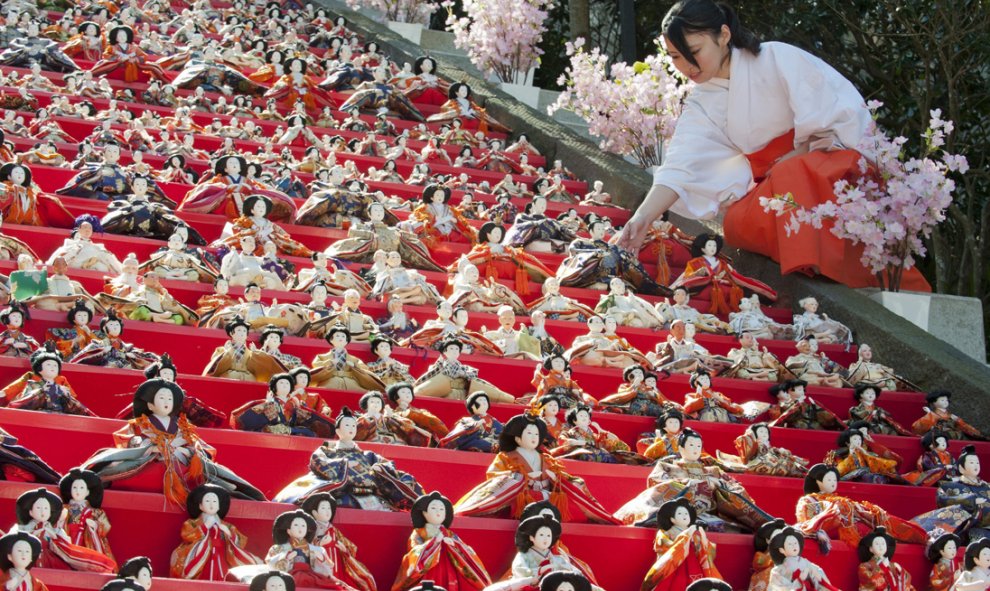 Una sacerdotisa Shinto coloca una muñeca Hina sobre los peldaños de la escalera que conduce al santuario Shinto durante la celebración del "Hina matsuri", o Festival de las Muñecas, en Ciudad Katsuura, Japón. EFE/Everett Kennedy Brown