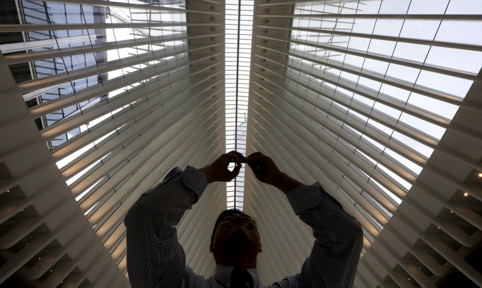 Un hombre toma una foto del techo del centro de transporte del World Trade Center en Nueva York. EFE/ANDREW GOMBERT