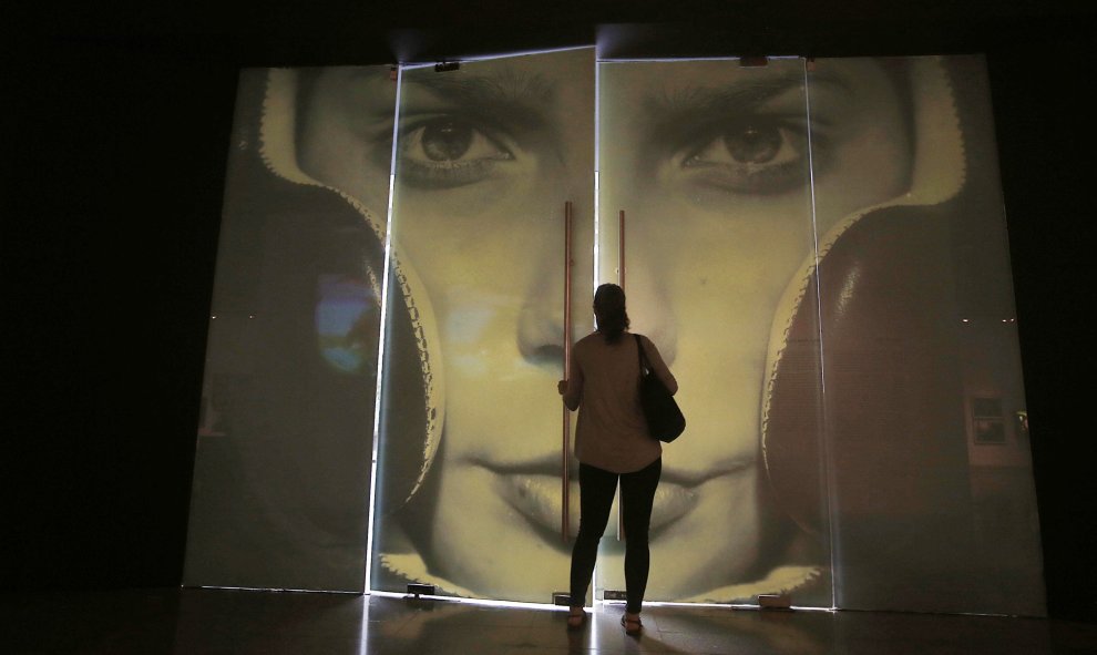 Una mujer entra en la exposición fotográfica 'Álbum de Chile' en el Centro Cultural Palacio de La Moneda, en Santiago de Chile. EFE/Mario Ruiz