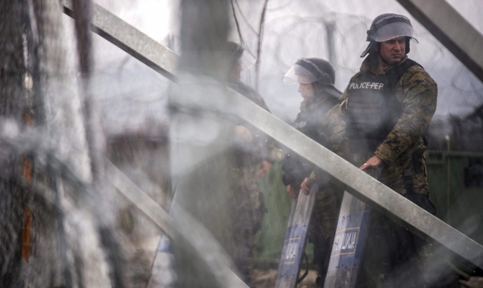 Agentes de policía montan guardia junto a un alambre de púas cerca de Gevgelija, en la frontera Grecia y Macedonia. EFE/Zoltan Balogh