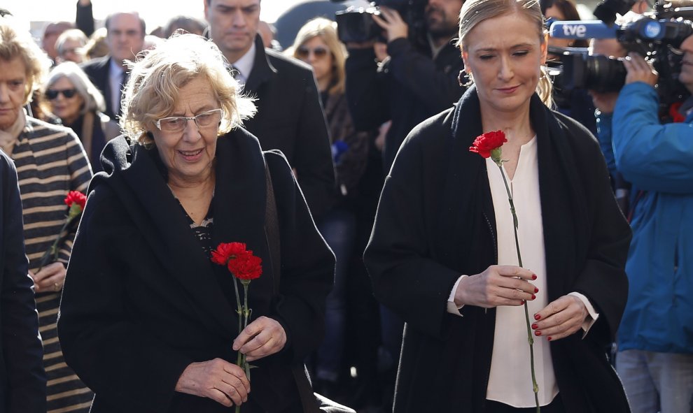 Cristina Cifuentes (d), y la alcaldesa de la capital, Manuela Carmena, durante el homenaje a las 193 personas asesinadas en los atentados yihadistas del 11 de marzo de 2004 esta mañana en la Estación de Atocha Cercanías.- EFE