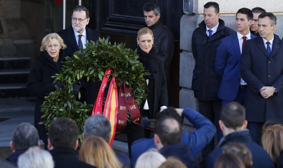 Cristina Cifuentes (d), y la alcaldesa de la capital, quienes han colocado esta mañana una corona de flores en la Puerta del Sol.- EFE