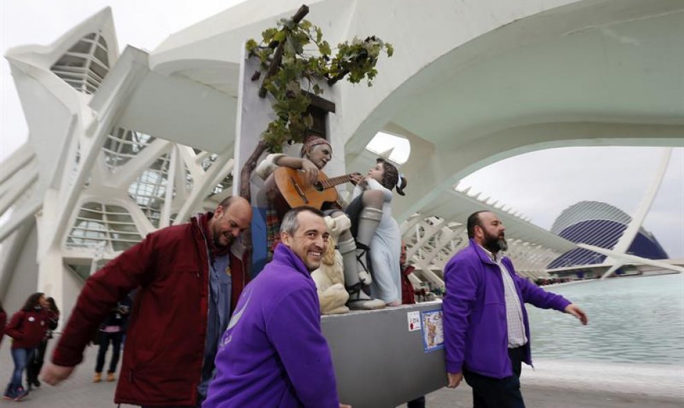 Un grupo de falleros se llevan la figura de un labrador valenciano tocando la guitarra, acompañado de un niño y un perro, que ha sido el grupo que ha conseguido el indulto en las Fallas 2016, obra del artista Manuel Algarra para la falla Almirante Cadarso