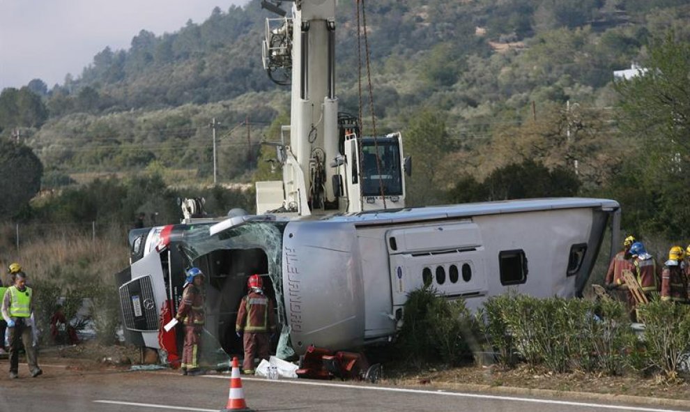 Una grúa trabaja para remolcar el autobús siniestrado. EFE/Jaume Sellart