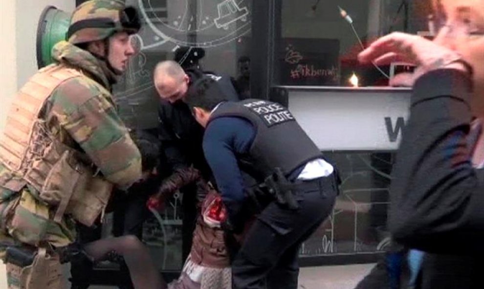 Agentes de Policía atienden a una mujer en el lugar de la explosión en la estación de metro de Malbeek, el barrio europeo de Bruselas. EFE
