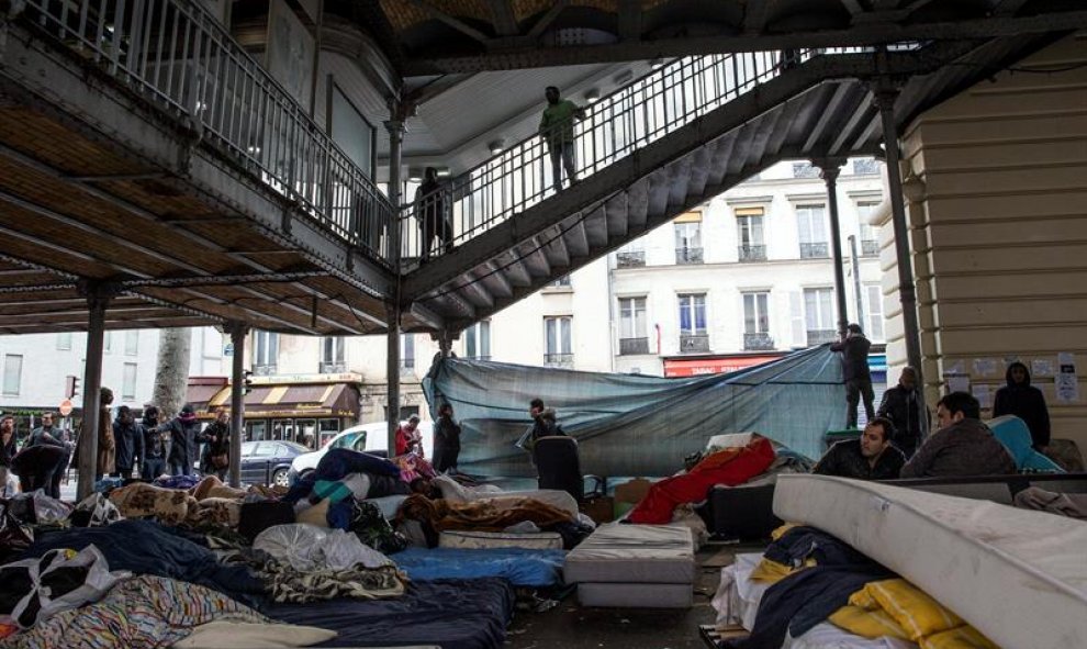 Migrantes procedentes de Afganistán, Sudán, y Eritrea montan un campamento temporal debajo de la estación de metro Stalingrad en París, Francia. EFE/Etienne