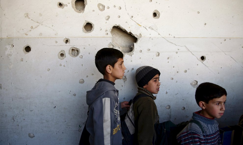 Estudiantes permanecen en su escuela dañada en una zona controlada por los rebeldes en Damasco. REUTERS/Bassam Khabieh