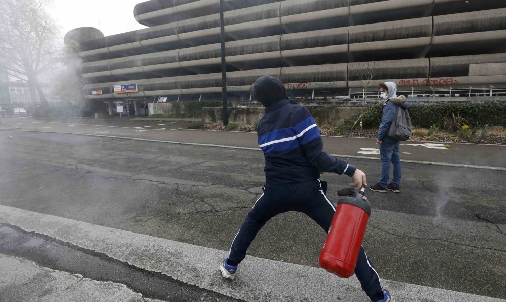 Un joven lanza un extintor de incendios durante los enfrentamientos con los gendarmes. REUTERS