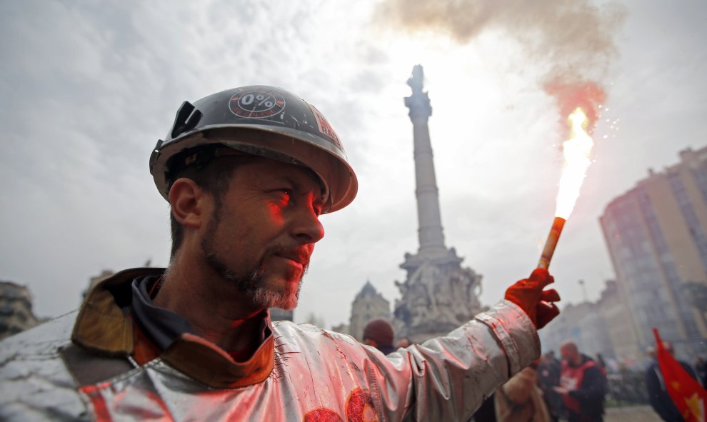 Un minero vestido con un traje protector sujeta una bengala en una manifestación en contra de la reforma laboral francés en Marsella, Francia. REUTERS