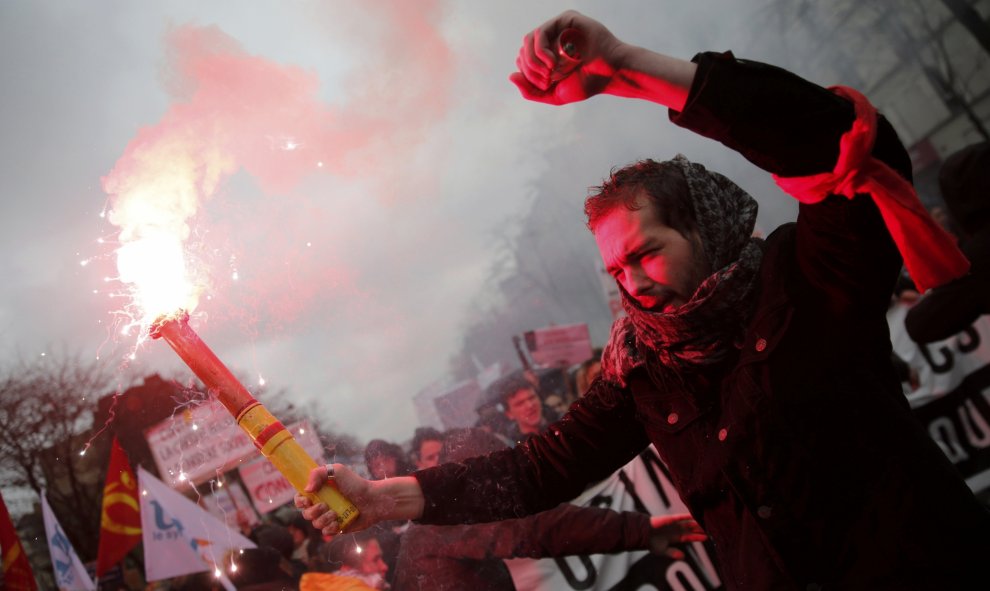 Universitarios franceses asisten con bengalas a una manifestación en París en contra de reforma laboral propuesta por Hollande. REUTERS