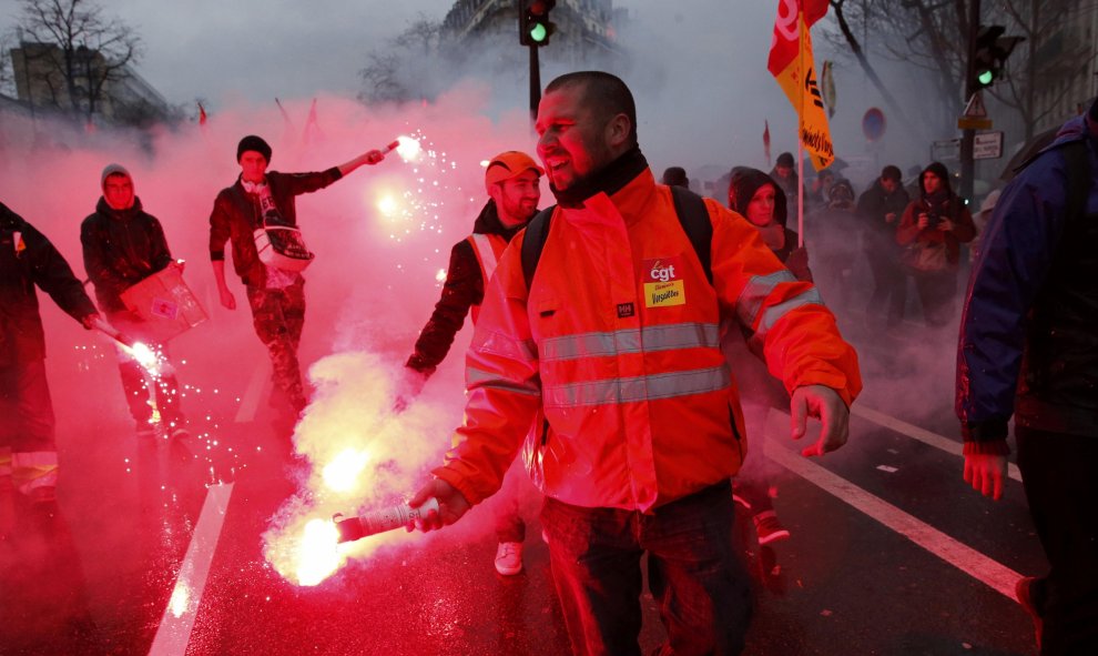 Varios trabajadores franceses del ferrocarril llevan bengalas en una manifestación en contra de la reforma laboral en París, Francia./ REUTERS / Benoit Tessier