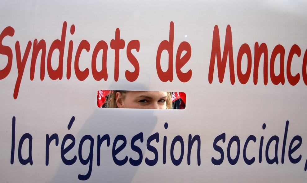 Un miembro de un sindicato obrero de Monaco mira a través de una pancarta durante una manifestación en contra de la reforma laboral francesa en Niza, Francia. REUTERS / Eric Gaillard