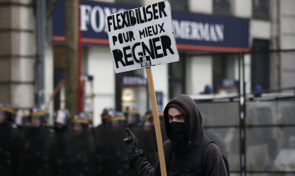 Un joven sostiene una pancarta cerca de los antidisturbios durante una manifestación en contra de la reforma laboral francesa en Lille, Francia. REUTERS / Pascal Rossignol