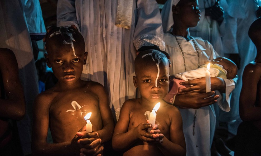 Jóvenes africanos son bautizados durante la celebración de una misa en una iglesia oriental en Kibera, en Nairobi, Kenia. FREDRIK LERNERYD / AFP