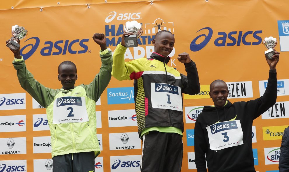 Los kenianos Morris Gachaga (c), John Kipsang Lotiang (i) y Philip Koech en el podio tras conseguir el primero, segundo y tercer puesto, respectivamente, en el ASICS Medio Maratón de Madrid. EFE/Juan Carlos Hidalgo