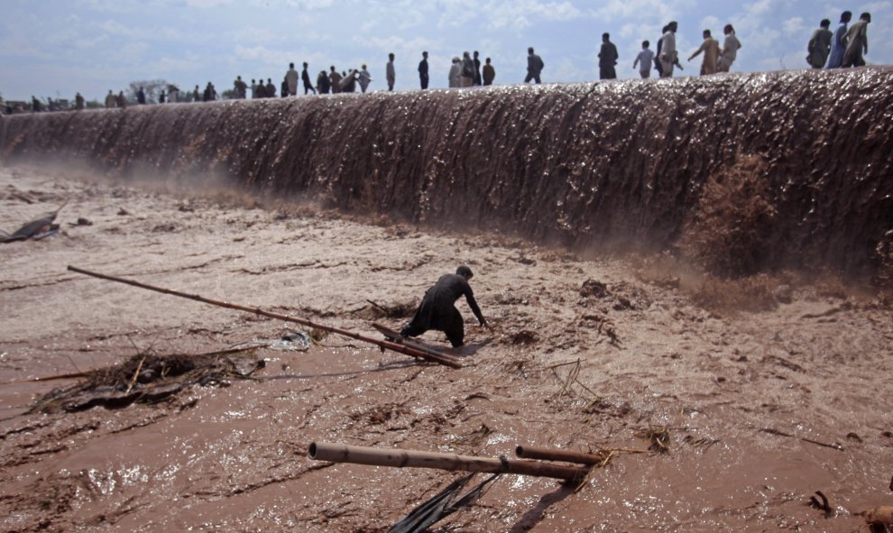 Un comerciante trata de salvar sus pertenencias tras la inundación por las fuertes lluvias en el distrito de Nowshera, en las afueras de Peshawar, Pakistán. REUTERS/Fayaz Aziz