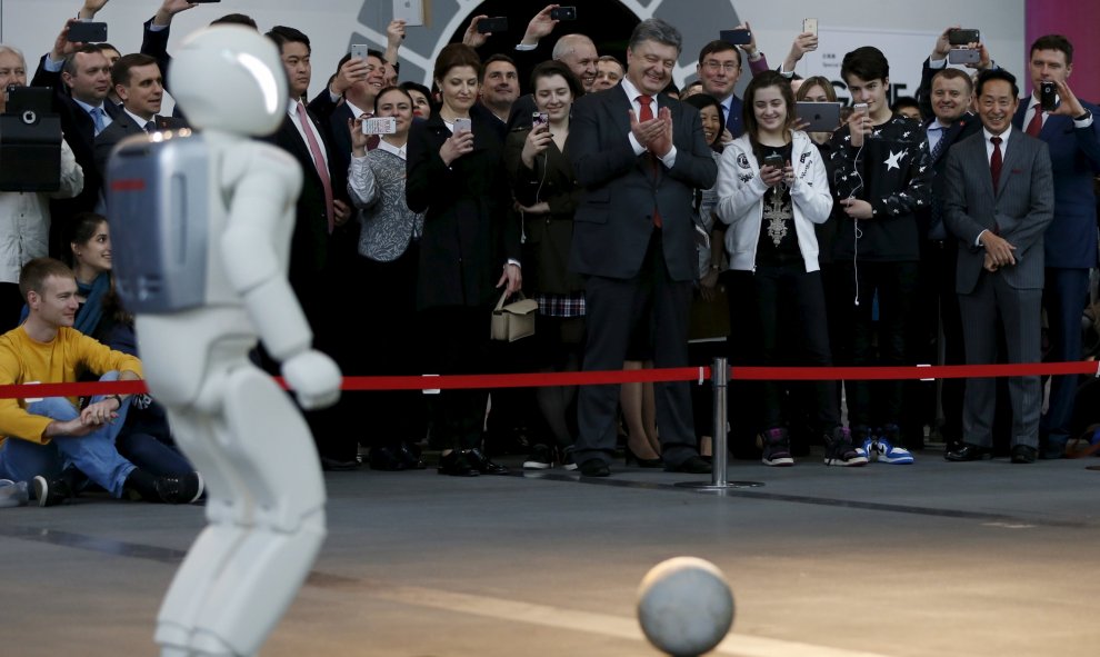 El presidente de Ucrania, Petro Poroshenko, aplaude mientras observa una actuación de un robot en Tokio. REUTERS/Issei Kato