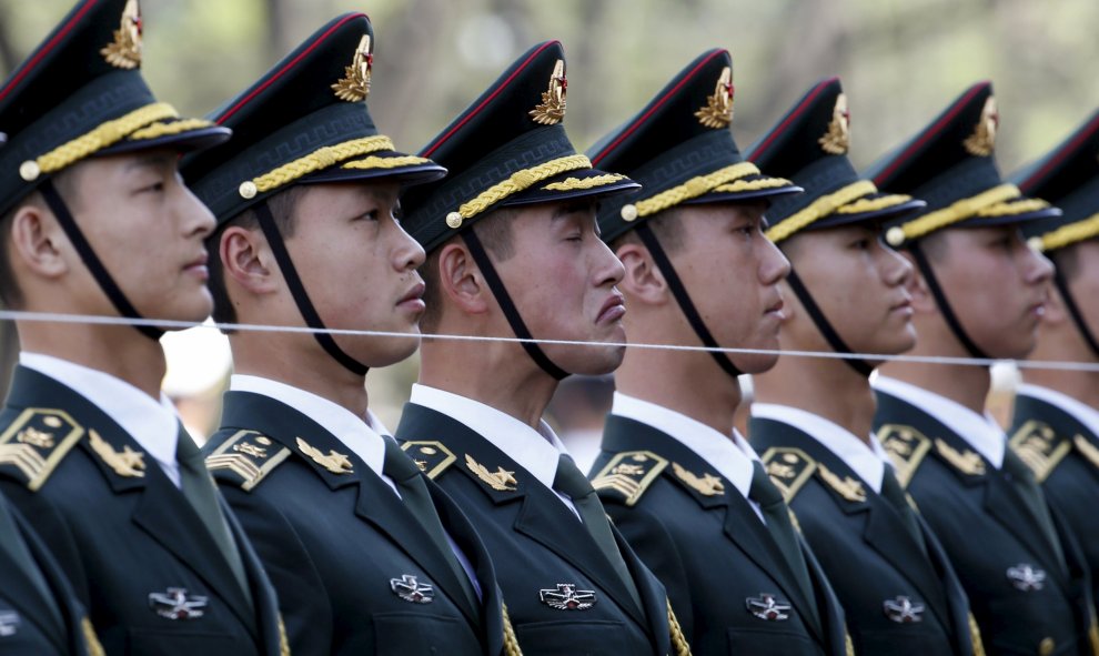 Los miembros del Ejército de Liberación chino permanece detrás de una cadena para asegurarse de que están en una línea recta antes de una ceremonia de bienvenida para el presidente suizo Johann Schneider-Ammann en Pekín. REUTERS/Kim Kyung-Hoon