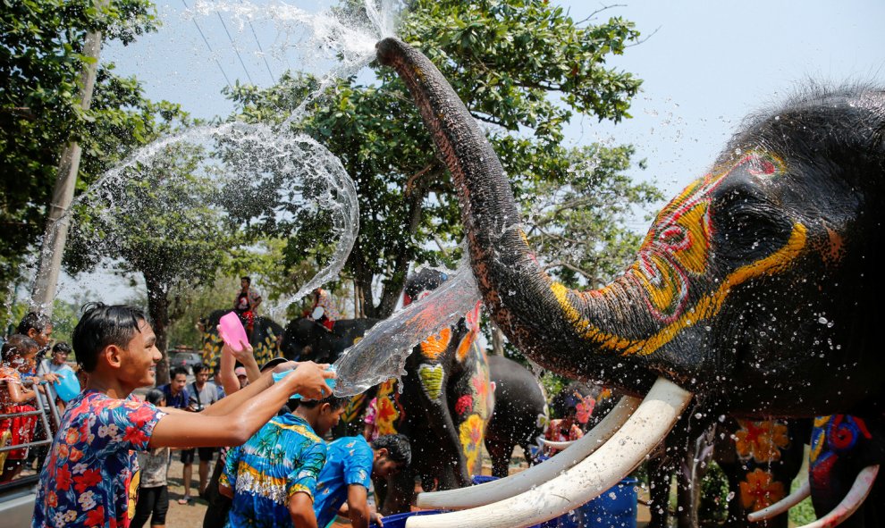 Un niño y un elefante se salpican el uno al otro con agua durante la celebración del festival de Songkran en la provincia de Ayutthaya de Tailandia. REUTERS/Jorge Silva