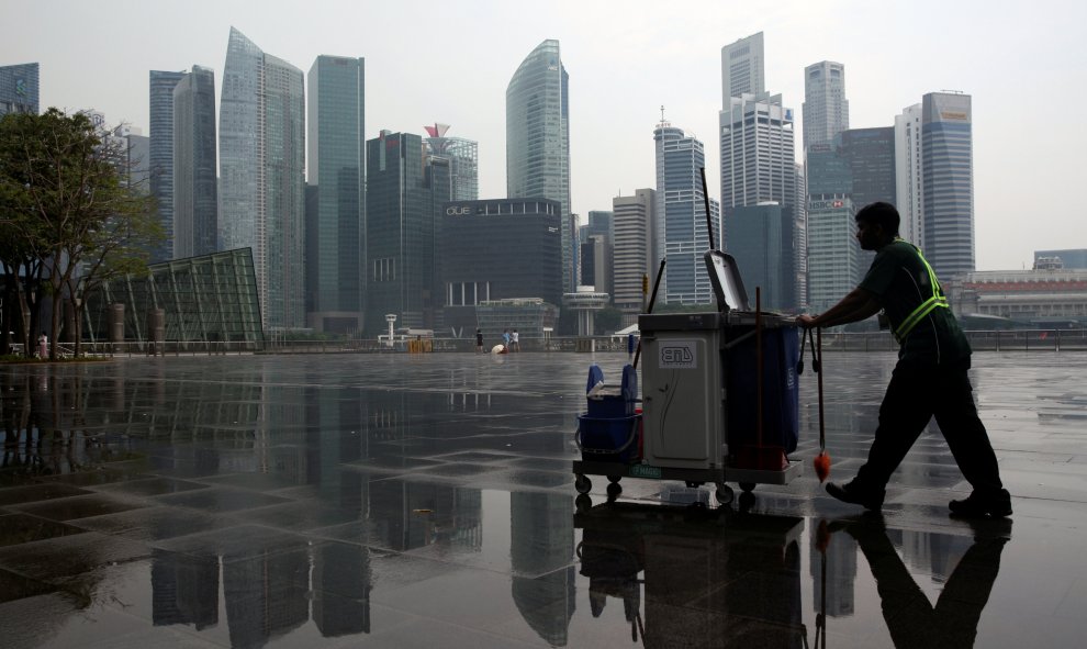 Un barrendero trabaja con el skyline de Singapur de fondo. /REUTERS-Edgar Su