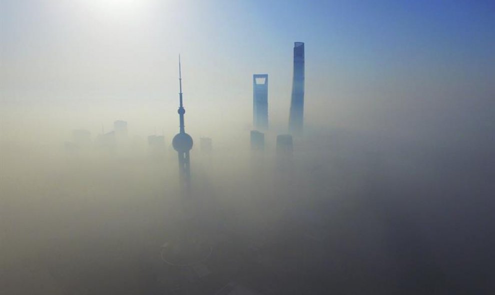 Vista aérea de los rascacielos cubiertos por una densa manta de niebla en Shanghái, China. EFE/Shen Chunchen