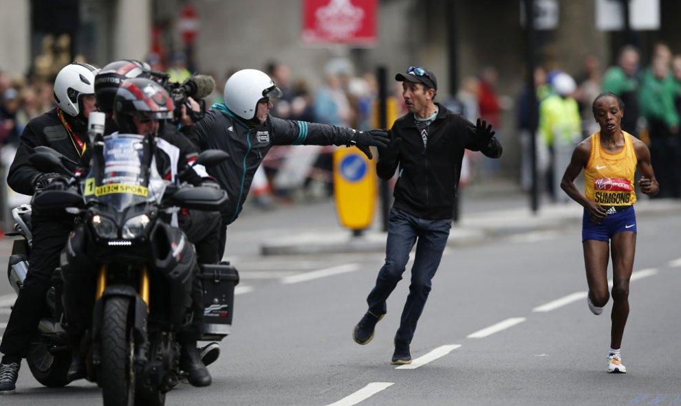 Miembros de la seguridad de la maraton de Londres tratan de controlar a un espectador que se ha acercado a la keniata Jemima Sumgong. REUTERS / Peter Cziborra